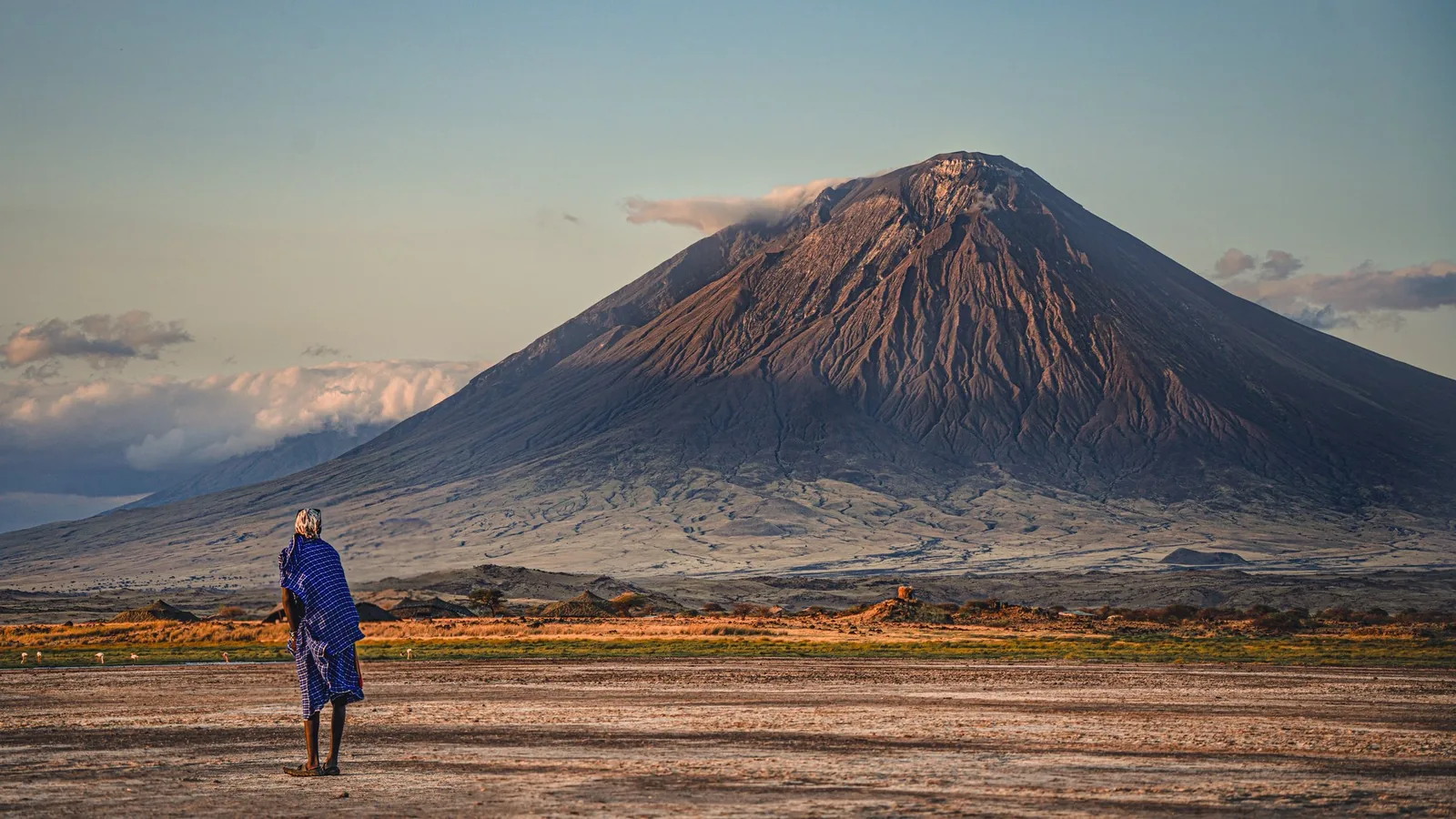 Maasai man looking towards Ol Doinyo Lengai volcano from Lake Natron, Tanzania